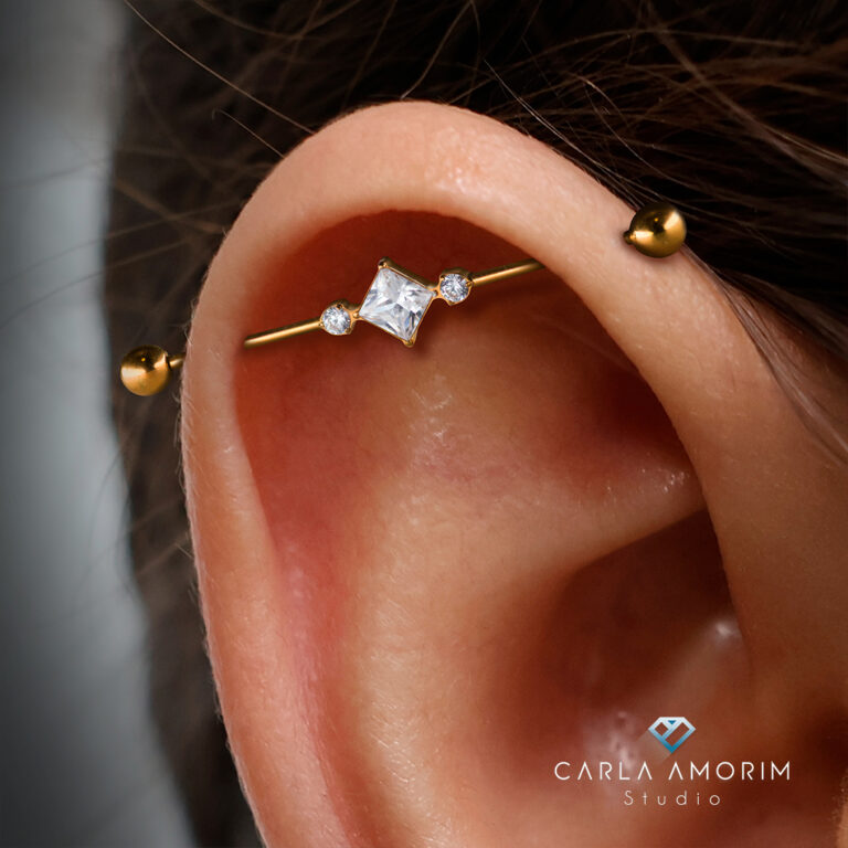 Piercing industrial (transversal) atravessando a cartilagem da orelha